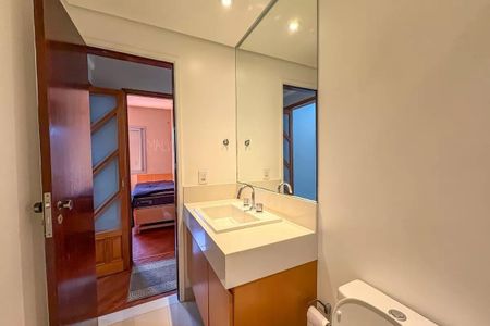 Apartamento à venda com 96m², 4 quartos e 2 vagas Apartamento à venda com 96m², 4 quartos e 2 vagasBanheiro com pia e vaso sanitário, com porta de madeira e espelho grande.