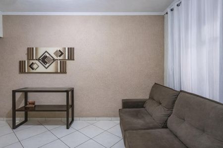 Sala com sofá e mesa de madeira, com decoração em tons de bege e cinza. de casa à venda com 3 quartos, 160m² em Casa Grande, Diadema