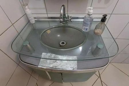 Casa à venda com 160m², 3 quartos e 2 vagasVidro sobre o lavabo, com sabonete e gel de higiene, em um banheiro simples.