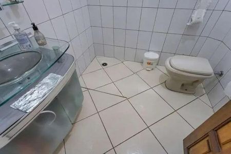 Casa à venda com 160m², 3 quartos e 2 vagasBanheiro com piso de porcelanato, vaso sanitário e pia de vidro.