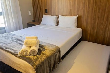 Quarto com cama de casal, colchão de espuma, cortina de vela e tapete de lã, com uma mesa de cabeceira e uma lâmpada de mesa. de kitnet/studio à venda com 1 quarto, 22m² em Perdizes, São Paulo