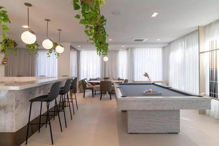 Sala de jogos com mesa de bilhar e bar, iluminada por lâmpadas de design e com plantas suspensas. de kitnet/studio à venda com 1 quarto, 22m² em Perdizes, São Paulo