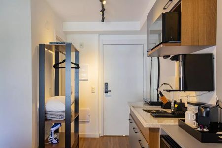 Quarto com cozinha integrada, iluminado por luz natural e artificial, com móveis de madeira e azulejos no chão. de kitnet/studio à venda com 1 quarto, 22m² em Perdizes, São Paulo
