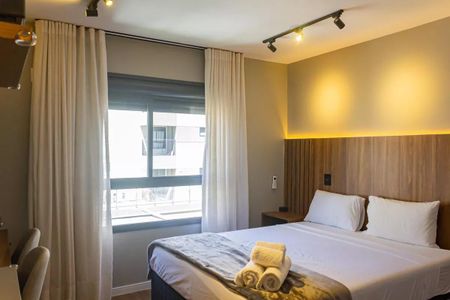 Quarto com cama de casal, cortinas, iluminação e vista para o exterior. de kitnet/studio à venda com 1 quarto, 22m² em Perdizes, São Paulo