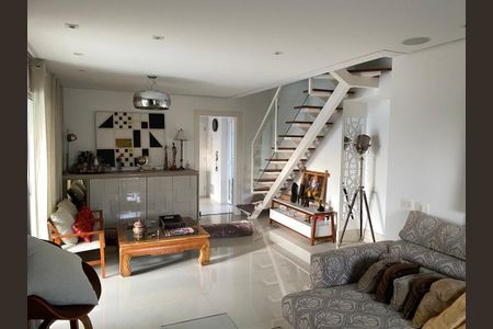 Sala com móveis de madeira e decoração minimalista, iluminada por lâmpadas e com uma escada de madeira e vidro. de apartamento à venda com 6 quartos, 220m² em Santo Amaro, São Paulo