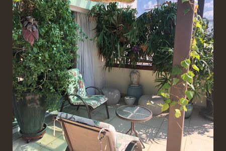 Apartamento à venda com 220m², 6 quartos e 3 vagas Apartamento à venda com 220m², 6 quartos e 3 vagasVaranda com duas cadeiras e mesa, com plantas ao redor, com vista para o mar.