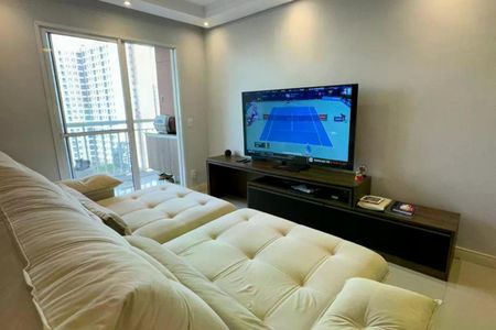 Sala de estar com sofá branco e TV na parede, com vista para a cidade. de apartamento à venda com 2 quartos, 64m² em Vila Piratininga, São Paulo