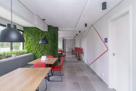 Sala de espera com mesa e cadeiras vermelhas, paredes de plantas e iluminação moderna. de apartamento à venda com 2 quartos, 42m² em Cidade Antônio Estêvão de Carvalho, São Paulo