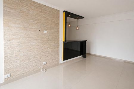 Sala com parede de pedra, iluminação moderna e móveis em tons de preto e amarelo. de apartamento à venda com 2 quartos, 66m² em Jardim São Paulo, São Paulo