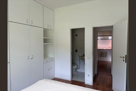 Apartamento para alugar com 100m², 3 quartos e 1 vagaQuarto com móveis brancos, piso de madeira e porta de vidro.