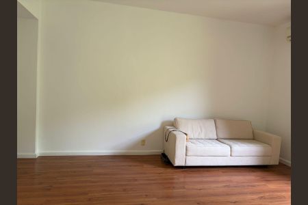 Apartamento para alugar com 100m², 3 quartos e 1 vagaSala com sofá branco e piso de madeira, iluminada por luz natural.