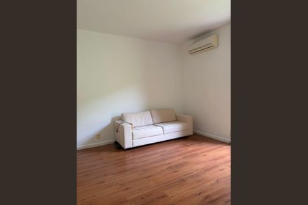 Apartamento para alugar com 100m², 3 quartos e 1 vagaSala com sofá branco e piso de madeira, com ar condicionado na parede.