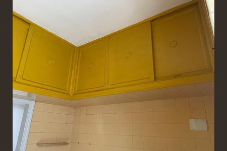 Apartamento para alugar com 125m², 3 quartos e 1 vagaCobertura com armários amarelos e teto branco, parede com azulejos amarelos e piso branco.