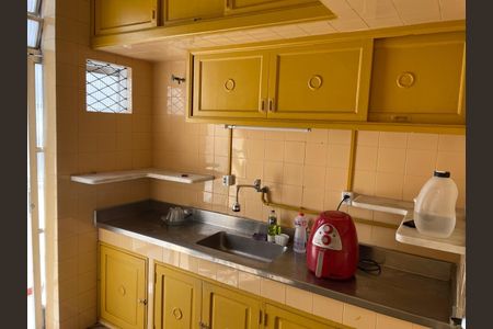 Apartamento para alugar com 125m², 3 quartos e 1 vagaCozinha com móveis amarelos e azulejos amarelos, com uma geladeira vermelha e uma pia de aço.