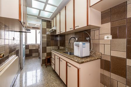 Apartamento à venda com 106m², 2 quartos e 2 vagas Apartamento à venda com 106m², 2 quartos e 2 vagasCozinha com móveis de madeira e azulejos em tons de marrom e creme, com iluminação natural e equipamentos de cozinha modernos.