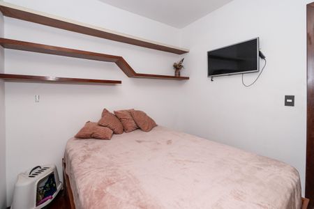 Apartamento à venda com 106m², 2 quartos e 2 vagas Apartamento à venda com 106m², 2 quartos e 2 vagasCama simples com colchão e travesseiros, com TV na parede e prateleiras de madeira acima.