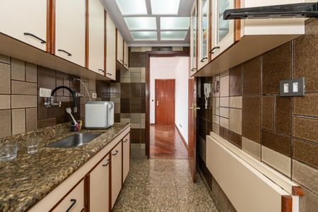 Apartamento à venda com 106m², 2 quartos e 2 vagas Apartamento à venda com 106m², 2 quartos e 2 vagasCozinha com móveis de madeira e azulejos em tons de marrom e creme.