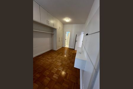 Quarto com móveis brancos e piso de madeira, iluminado por uma lâmpada de teto. de apartamento para alugar com 3 quartos, 150m² em Leblon, Rio de Janeiro