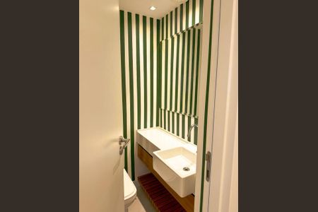 Banheiro com piso de porcelanato, pia de cerâmica e armário de madeira, com decoração em verde e branco. de apartamento para alugar com 2 quartos, 84m² em Leblon, Rio de Janeiro