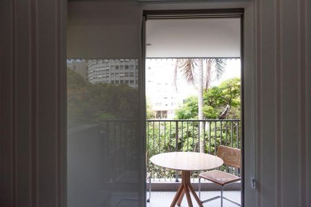 Varanda com mesa e cadeira, com vista para o jardim e edifício ao fundo. de apartamento para alugar com 2 quartos, 84m² em Leblon, Rio de Janeiro