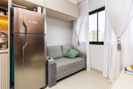 Sala de estar com sofá, geladeira e janela com vista para a cidade. de kitnet/studio à venda com 0 quarto, 24m² em Pompeia, São Paulo