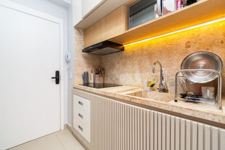 Cozinha com móveis de madeira e piso de porcelanato, iluminada por luzes de LED. de kitnet/studio à venda com 0 quarto, 24m² em Pompeia, São Paulo