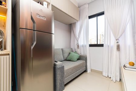 Sala de estar com geladeira e sofá, vista para a cidade. de kitnet/studio à venda com 0 quarto, 24m² em Pompeia, São Paulo