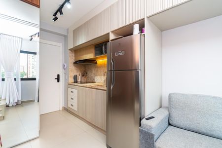Studio à venda com 24m², 0 quarto e sem vagaCozinha pequena com geladeira, fogão e micro-ondas, iluminada com luzes de LED.