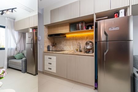 Studio à venda com 24m², 0 quarto e sem vagaCozinha com móveis de madeira e armários de gavetas, com geladeira e fogão, e iluminação adequada.