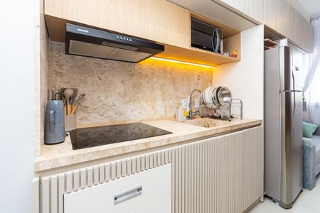 Studio à venda com 24m², 0 quarto e sem vagaCozinha com pia, fogão e geladeira, com iluminação adequada e móveis de madeira e pedra.