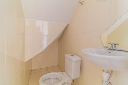 Casa à venda com 97m², 3 quartos e 2 vagasBanheiro com piso de porcelanato e vaso sanitário branco, com uma pia em porcelanato e um espelho acima dela.