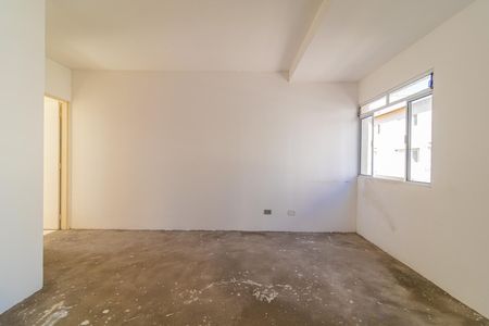 Casa à venda com 97m², 3 quartos e 2 vagasSala com paredes brancas e piso de concreto, com uma janela pequena na parede lateral.