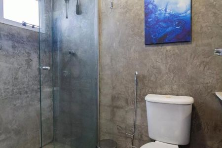 Banheiro com chuveiro e pia, com pintura azul e branca na parede, e uma janela pequena no canto superior esquerdo. de apartamento à venda com 2 quartos, 35m² em Jardim Paulista, São Paulo