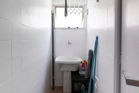 Apartamento à venda com 35m², 2 quartos e 1 vagaBanheiro com pia e vaso sanitário, paredes de azulejos brancos, janela pequena e porta de vidro.