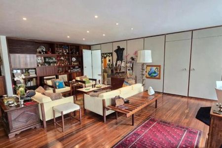 Apartamento à venda com 370m², 6 quartos e 3 vagas Apartamento à venda com 370m², 6 quartos e 3 vagasSala de estar com móveis de madeira e decoração moderna, com uma vista para a cidade.