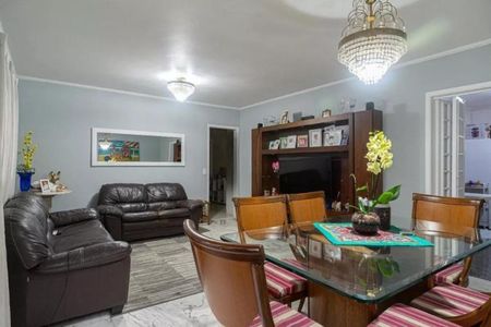 Sala de estar com sofá, mesa e cadeiras, iluminada por lâmpadas e com uma TV na parede. de apartamento à venda com 4 quartos, 115m² em Bela Vista, São Paulo