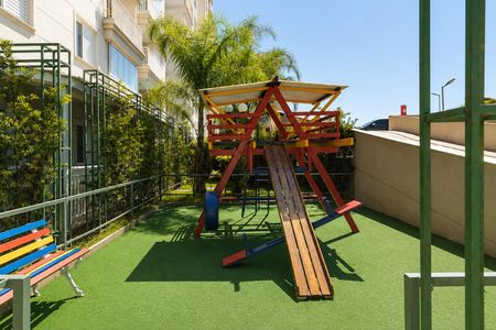 Apartamento à venda com 64m², 3 quartos e 2 vagas Apartamento à venda com 64m², 3 quartos e 2 vagasPraça de brinquedos colorida com escada e telhado, cercada por arbustos e edifícios.