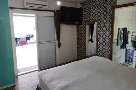 Casa à venda com 92m², 3 quartos e 2 vagas Casa à venda com 92m², 3 quartos e 2 vagasQuarto com cama, TV e porta para a varanda.