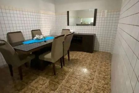Casa à venda com 92m², 3 quartos e 2 vagas Casa à venda com 92m², 3 quartos e 2 vagasTabela de madeira com quatro cadeiras e um tapete azul no centro.