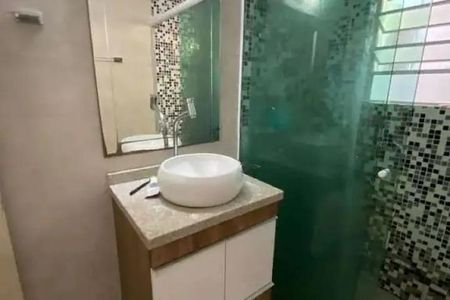 Casa à venda com 92m², 3 quartos e 2 vagas Casa à venda com 92m², 3 quartos e 2 vagasBanheiro com pia e espelho, com uma porta de vidro e uma janela pequena.
