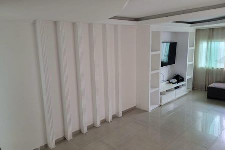 Sala de estar com TV e móveis brancos, parede com decoração em molduras verticais e piso de porcelanato. de casa à venda com 7 quartos, 200m² em Vila Paiva, São Paulo