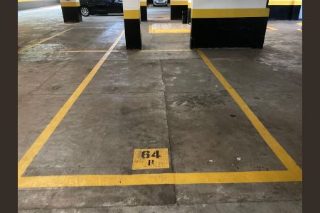 Apartamento à venda com 76m², 4 quartos e 2 vagas Apartamento à venda com 76m², 4 quartos e 2 vagasParked car in a garage with yellow lines and black and white pillars.
