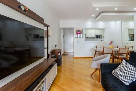 Apartamento à venda com 81m², 4 quartos e 2 vagas Apartamento à venda com 81m², 4 quartos e 2 vagasSala de estar com TV e sofá, com uma mesa e cadeiras para refeições, e uma cozinha com geladeira e fogão.