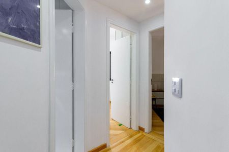 Apartamento à venda com 81m², 4 quartos e 2 vagas Apartamento à venda com 81m², 4 quartos e 2 vagasParede branca com porta aberta e porta fechada, com piso de madeira e quadro na parede.