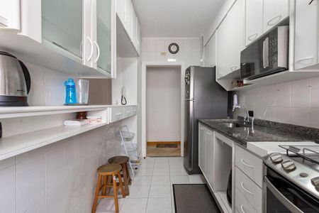 Apartamento à venda com 81m², 4 quartos e 2 vagas Apartamento à venda com 81m², 4 quartos e 2 vagasCozinha com móveis brancos e azuis, com uma geladeira e um fogão.