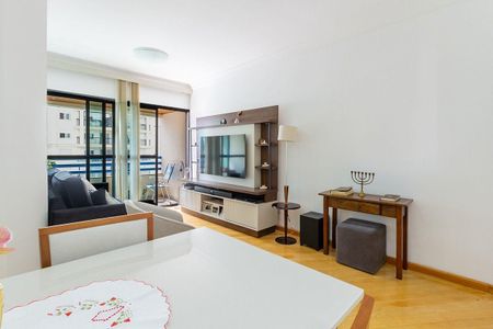 Apartamento à venda com 81m², 4 quartos e 2 vagas Apartamento à venda com 81m², 4 quartos e 2 vagasSala de estar com TV e sofá, vista para a varanda e edifício ao fundo.
