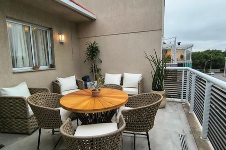 Apartamento à venda com 150m², 5 quartos e 2 vagas Apartamento à venda com 150m², 5 quartos e 2 vagasVaranda com mesa e cadeiras de madeira e wicker, com vista para a rua e o céu nublado.