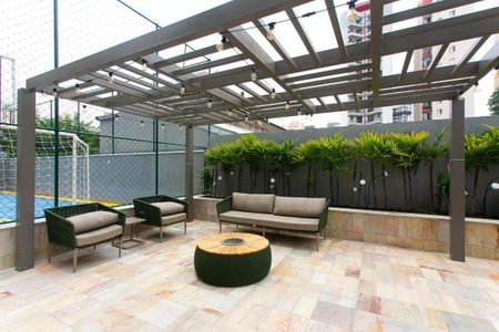 Apartamento à venda com 63m², 2 quartos e 1 vaga Apartamento à venda com 63m², 2 quartos e 1 vagaPátio com quadra de futsal, sofá, mesa e cadeiras, iluminação e plantas.