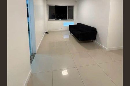 Sala com sofá de cor preta, paredes brancas e piso de porcelanato. de apartamento à venda com 2 quartos, 73m² em Barra da Tijuca, Rio de Janeiro