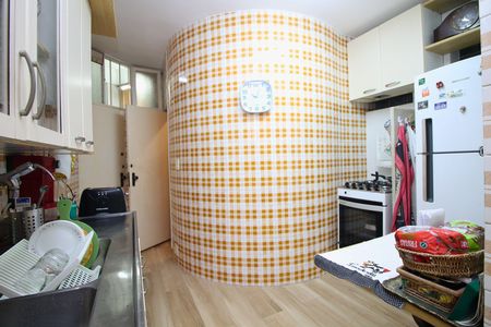 Apartamento para alugar com 108m², 2 quartos e 1 vaga Apartamento para alugar com 108m², 2 quartos e 1 vagaCozinha com piso de porcelanato, armários brancos e geladeira branca, com um relógio na parede.